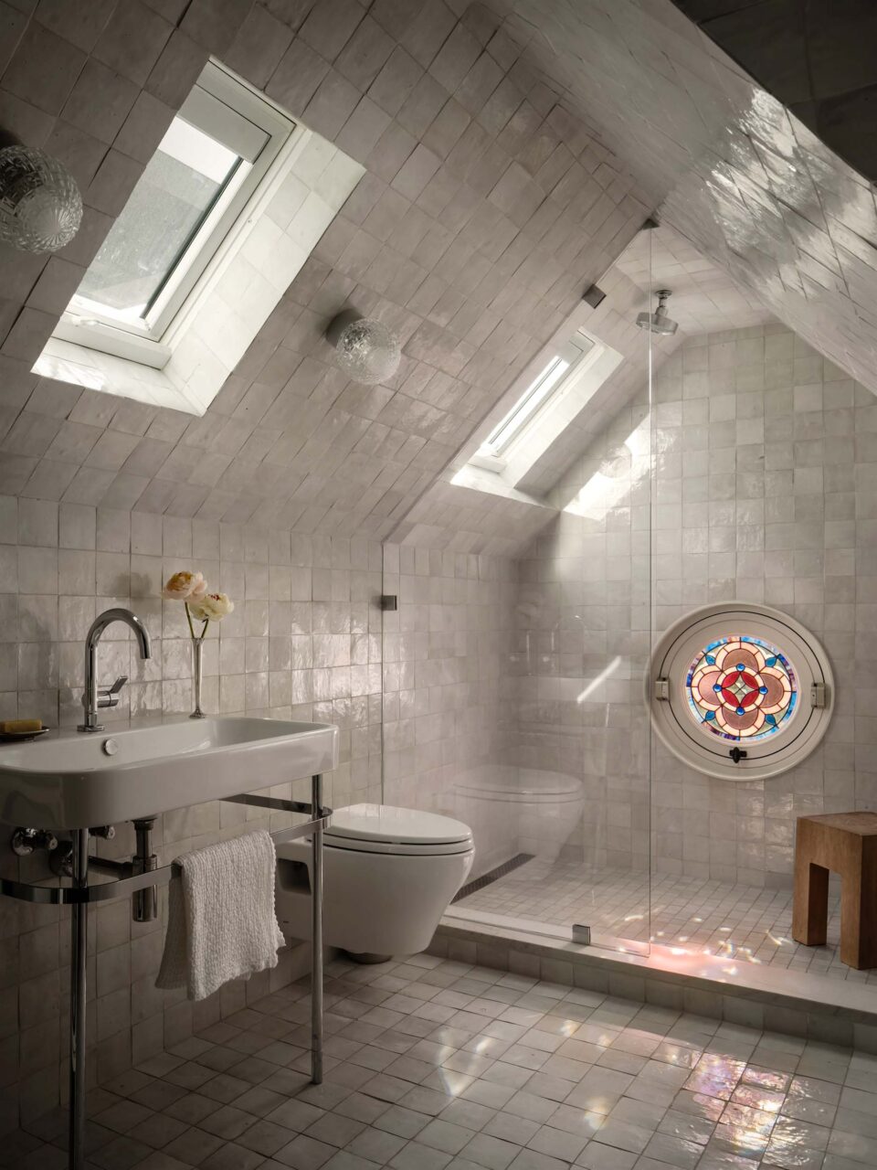 bathroom in attic covered in white tile