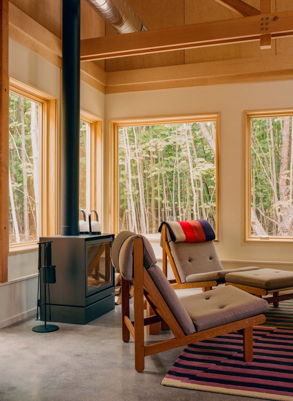 stove in living room with windows into the forest
