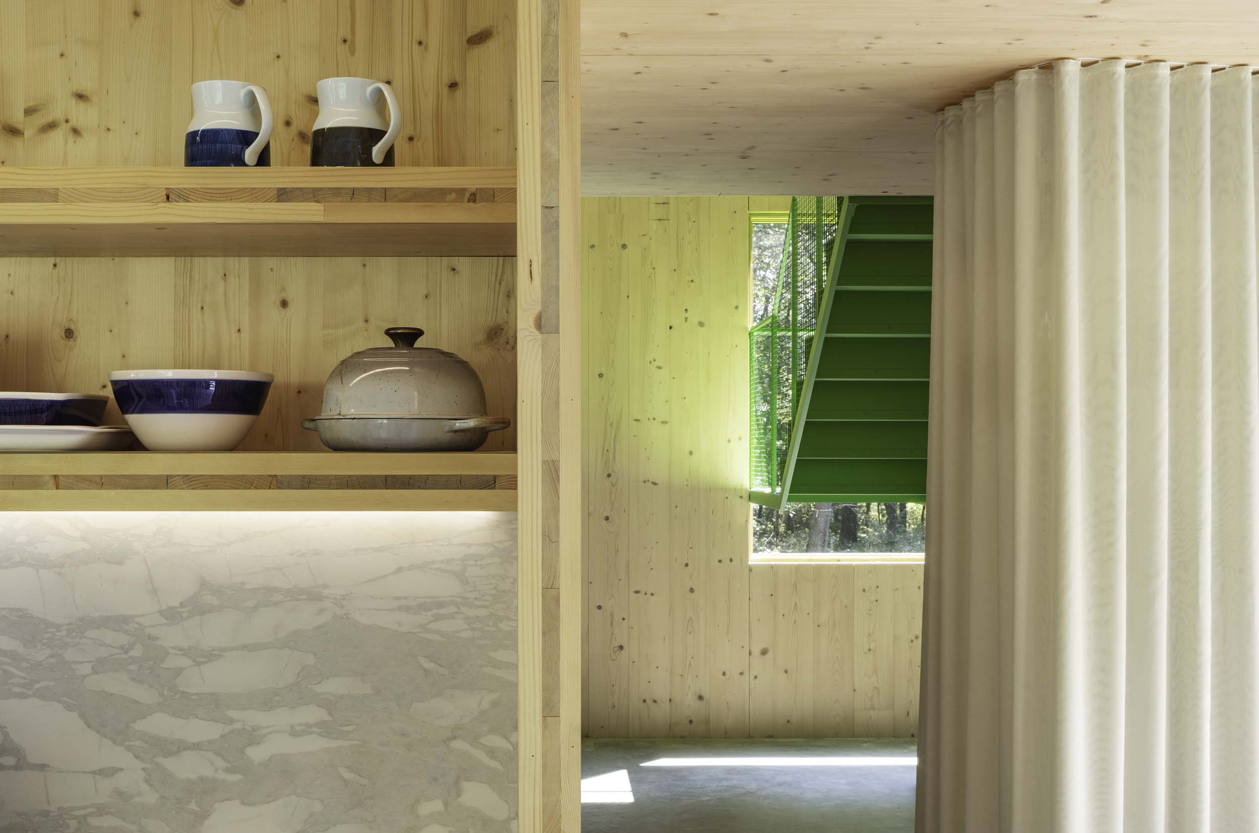 wood kitchen next to green staircase