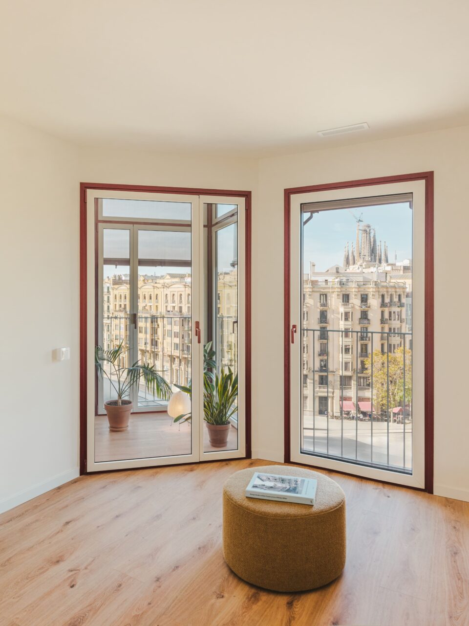 a room with a stool in front of windows