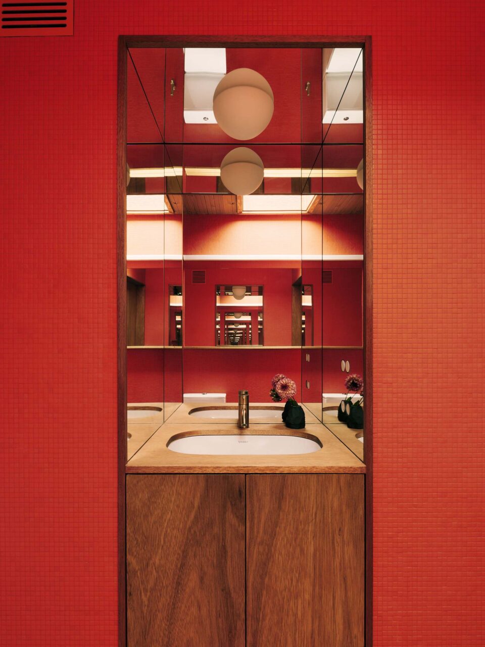 red-tiled bathroom with wooden vanity