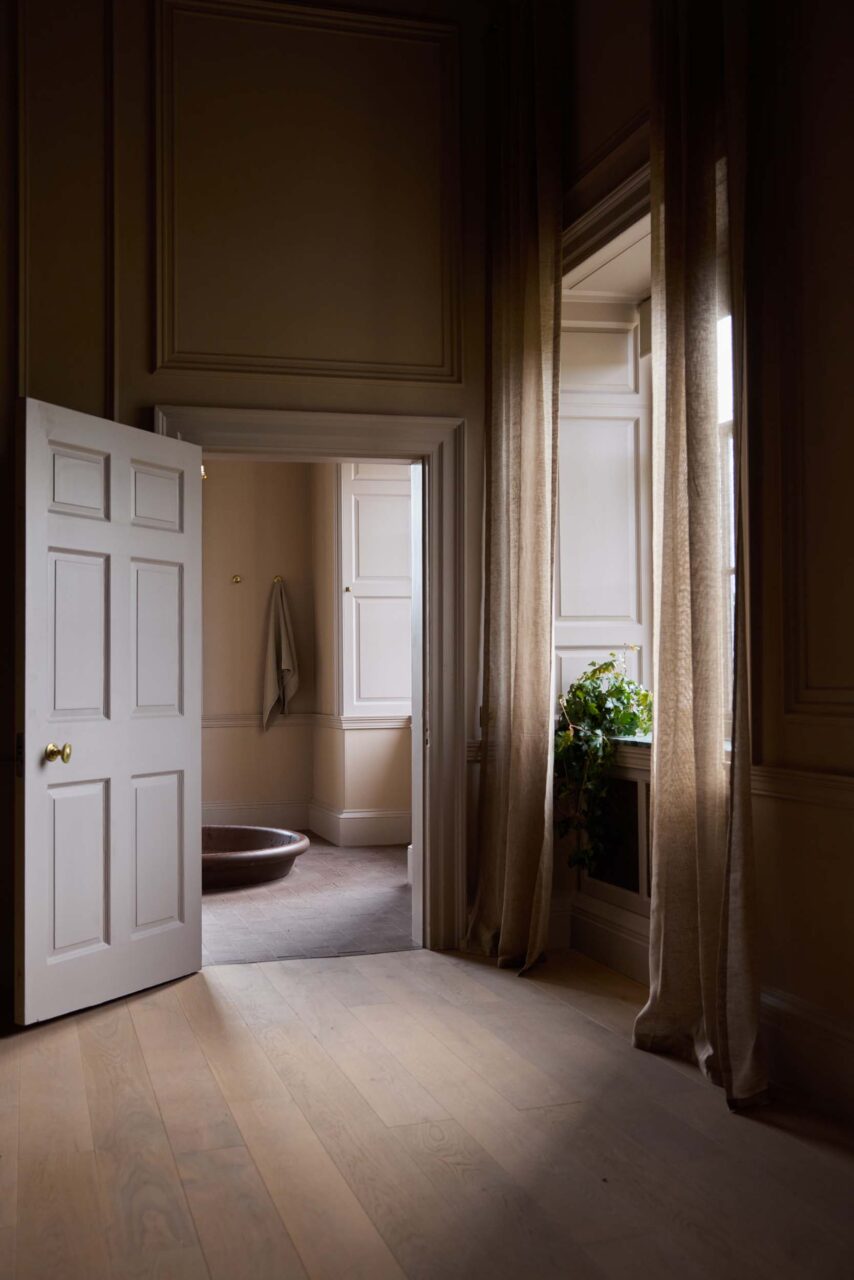 hallway with large windows into bathroom